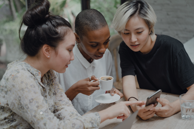 three ladies looking at their social metrics on their platforms